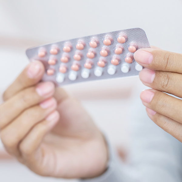woman holding birth control pills
