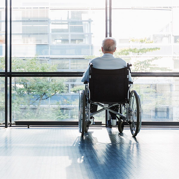Senior Man in Wheelchair looking out of a window