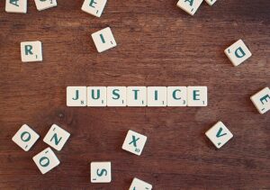 Letter tiles on a table spelling Justice